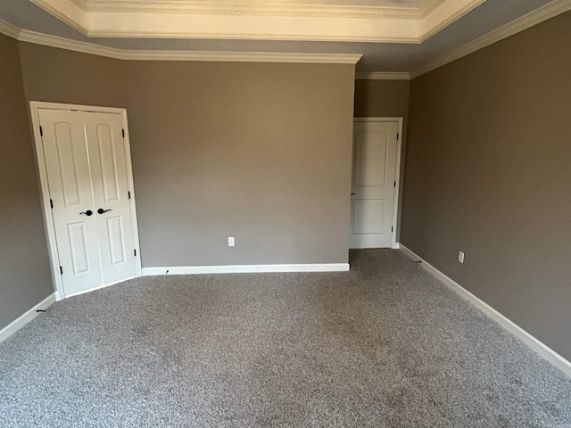 carpeted empty room with baseboards, a tray ceiling, and ornamental molding