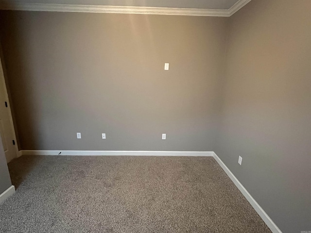 empty room with carpet, crown molding, and baseboards