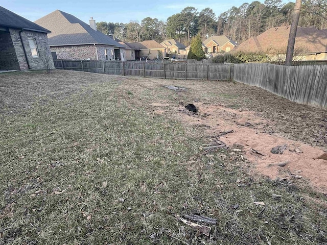 view of yard with a fenced backyard and a residential view