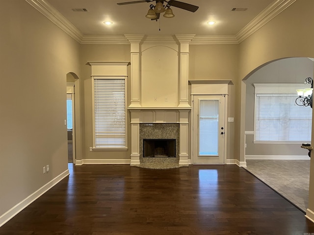 unfurnished living room with dark wood-style floors, a fireplace, visible vents, and crown molding