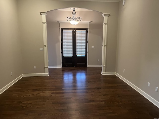 entryway with arched walkways, dark wood-style flooring, baseboards, french doors, and decorative columns