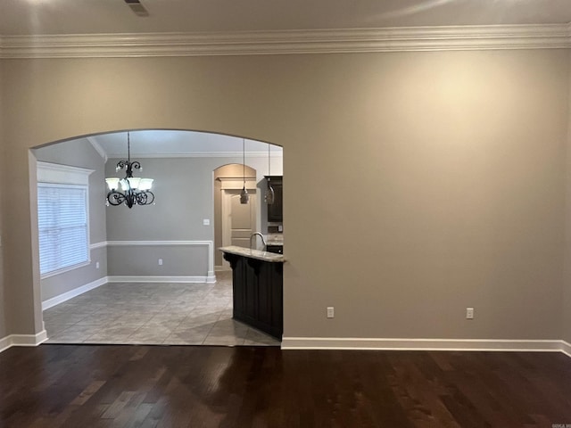 interior space featuring arched walkways, a chandelier, light wood-style flooring, and crown molding