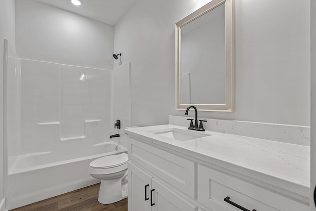 bathroom featuring washtub / shower combination, vanity, toilet, and wood finished floors