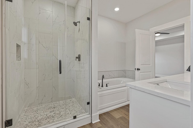 full bath with a garden tub, wood finished floors, and a shower stall