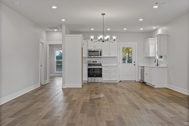 kitchen featuring wood finished floors, visible vents, light countertops, appliances with stainless steel finishes, and a wealth of natural light