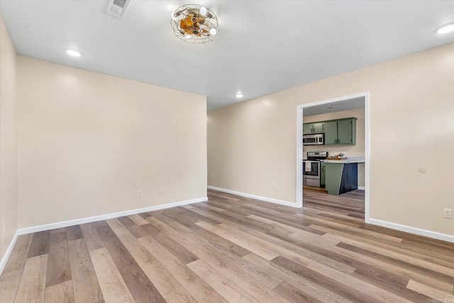 unfurnished room with baseboards, recessed lighting, visible vents, and light wood-style floors