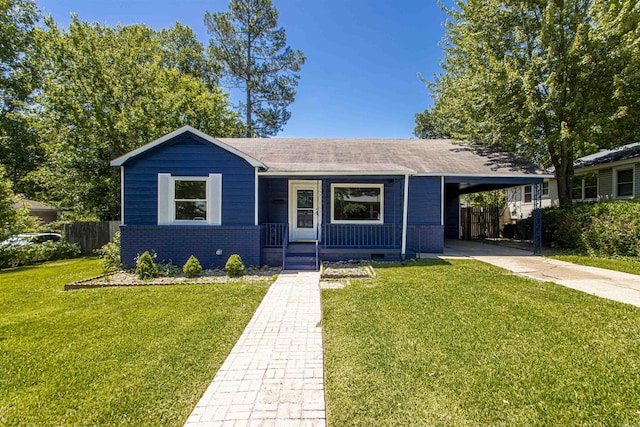 ranch-style home with driveway, brick siding, an attached carport, fence, and a front yard