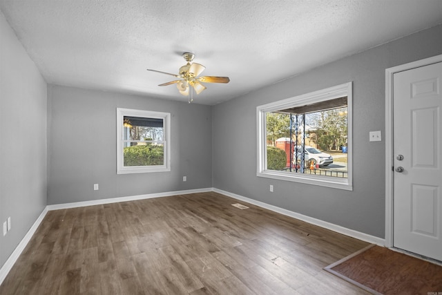 interior space with plenty of natural light, wood finished floors, and baseboards