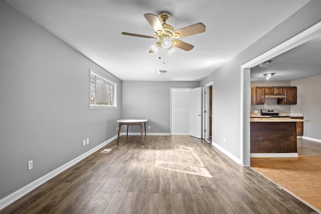 spare room featuring visible vents, ceiling fan, baseboards, and wood finished floors