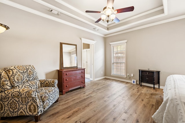 sitting room featuring a tray ceiling, visible vents, ornamental molding, wood finished floors, and baseboards