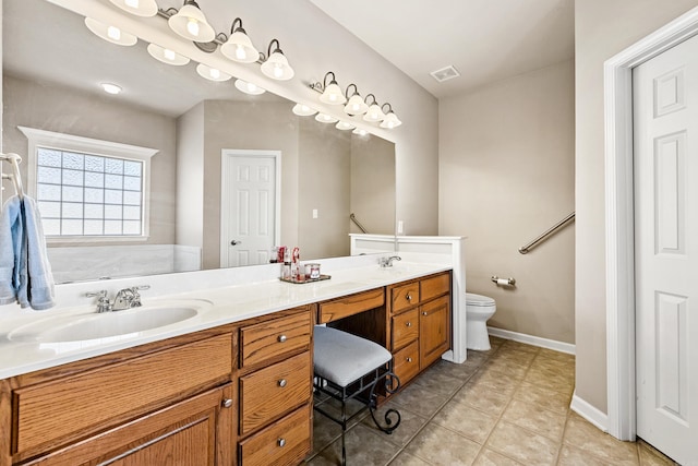 bathroom with double vanity, baseboards, toilet, tile patterned flooring, and a sink