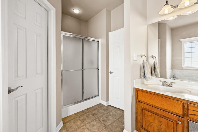 bathroom featuring tile patterned flooring, a shower stall, and vanity