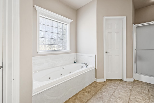 full bathroom featuring a stall shower, a jetted tub, baseboards, and tile patterned floors