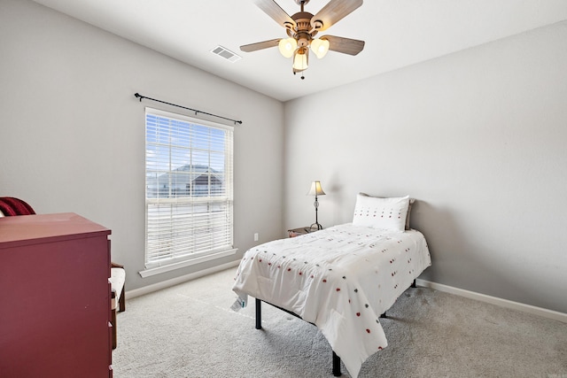 carpeted bedroom featuring ceiling fan, visible vents, and baseboards