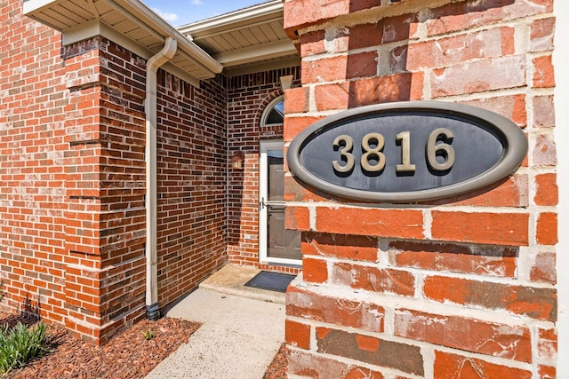 doorway to property featuring brick siding