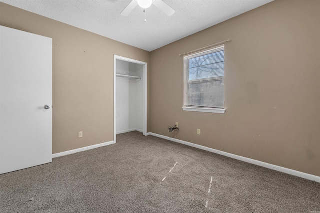 unfurnished bedroom with carpet floors, a textured ceiling, and baseboards