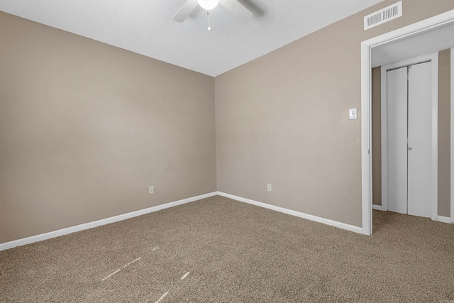 unfurnished room featuring carpet floors, visible vents, ceiling fan, and baseboards