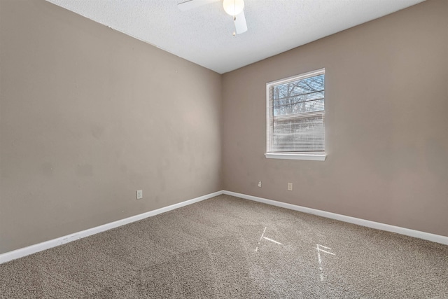 carpeted spare room featuring a ceiling fan, baseboards, and a textured ceiling