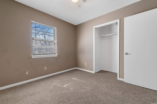 unfurnished bedroom with baseboards, ceiling fan, carpet, a textured ceiling, and a closet