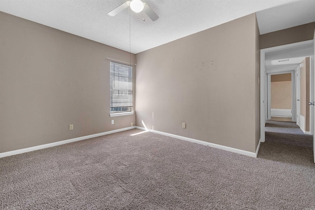 unfurnished room with a ceiling fan, carpet, a textured ceiling, and baseboards