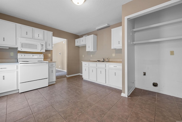 kitchen featuring white appliances, white cabinets, a sink, and light countertops