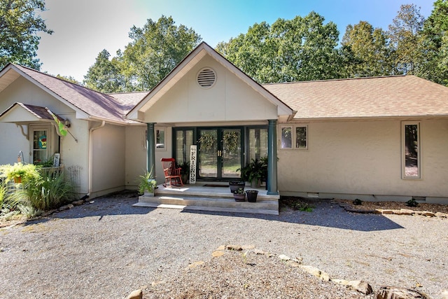 view of front of house with crawl space, roof with shingles, french doors, and stucco siding