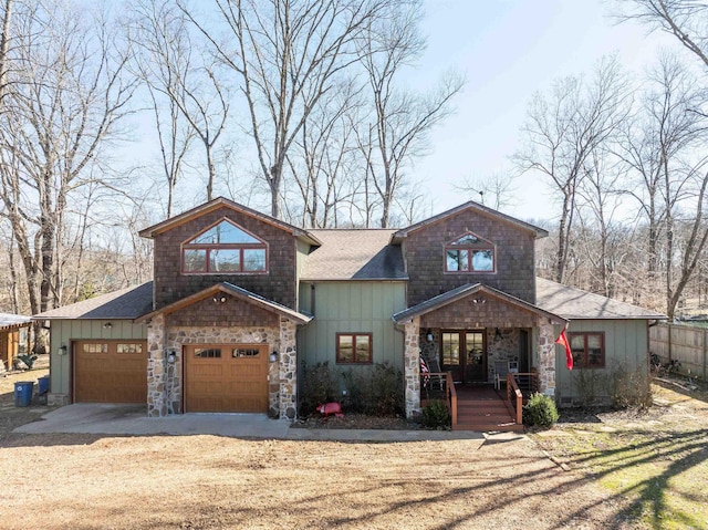 view of front of property with driveway, a garage, board and batten siding, and french doors