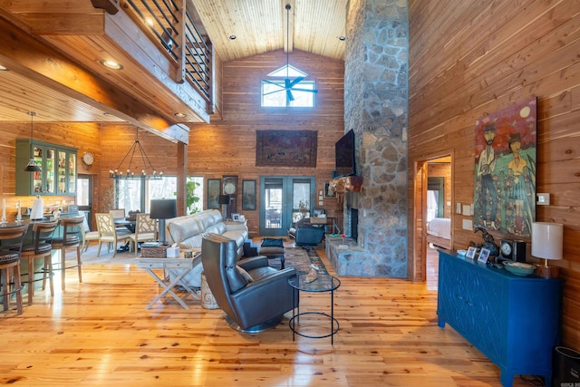 living area featuring wood walls, a fireplace, hardwood / wood-style flooring, and beamed ceiling