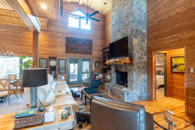 living room featuring a fireplace, wood walls, and wood finished floors