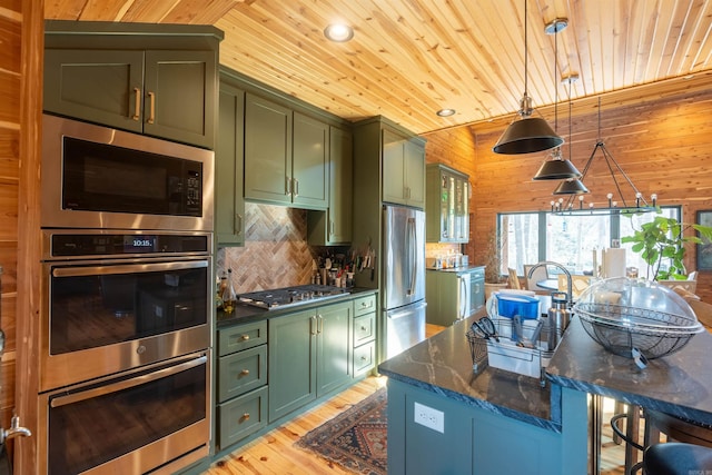 kitchen featuring appliances with stainless steel finishes, wooden ceiling, green cabinetry, and wood walls