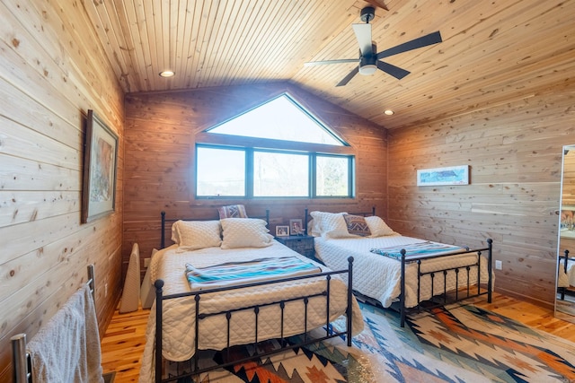 bedroom with wooden ceiling, ceiling fan, hardwood / wood-style floors, vaulted ceiling, and wood walls