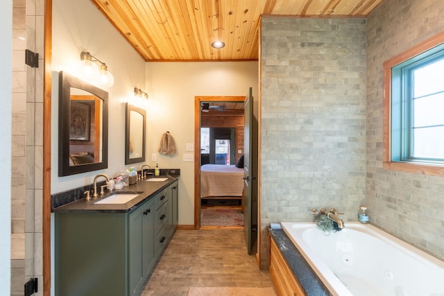 bathroom with double vanity, a tub with jets, wooden ceiling, and a sink