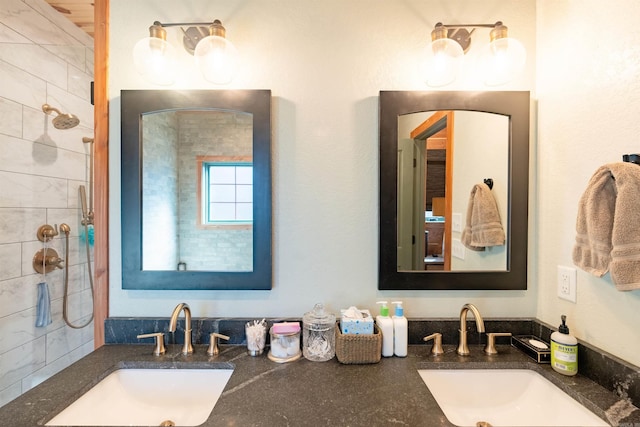 bathroom with a tile shower and vanity