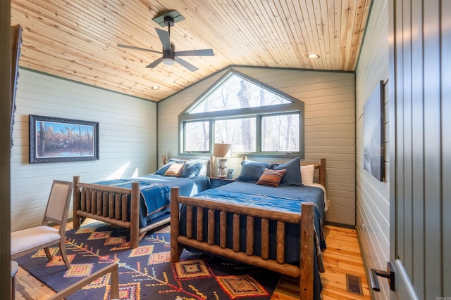 bedroom with lofted ceiling, wood walls, wood finished floors, visible vents, and wood ceiling