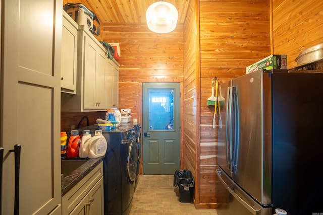 kitchen featuring wood walls, wood ceiling, white cabinetry, independent washer and dryer, and freestanding refrigerator