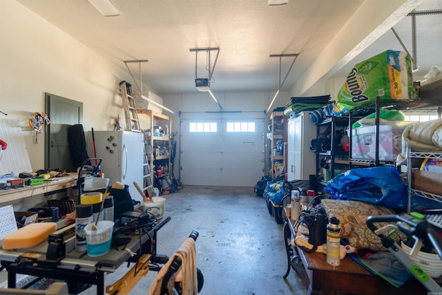 garage featuring freestanding refrigerator and a garage door opener