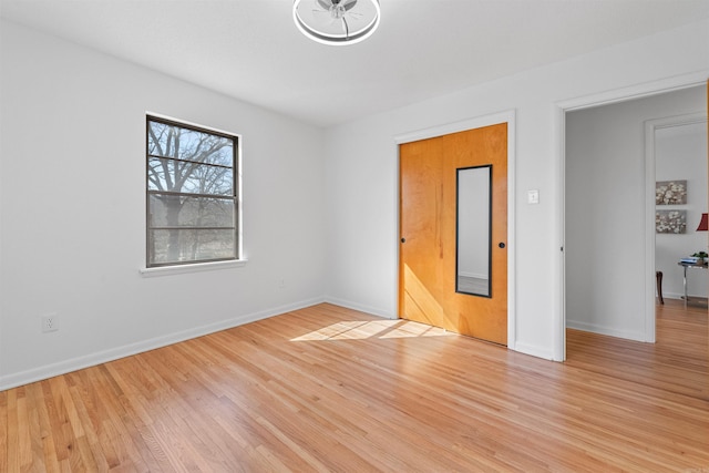 empty room featuring baseboards and light wood-style floors