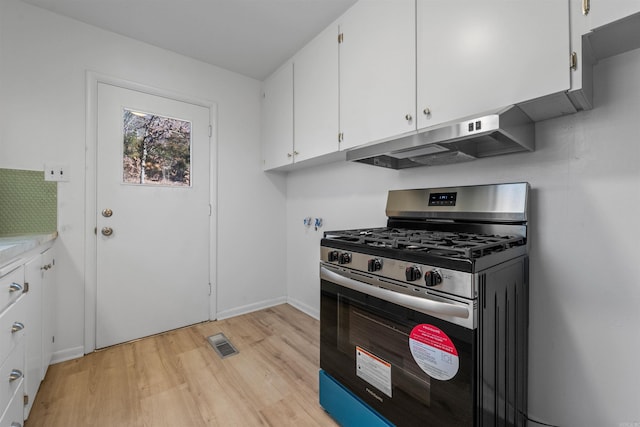 kitchen featuring stainless steel gas range oven, visible vents, white cabinets, light wood-type flooring, and under cabinet range hood