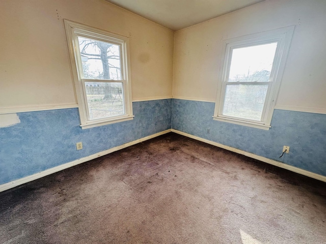 unfurnished room with carpet floors, wainscoting, baseboards, and wallpapered walls