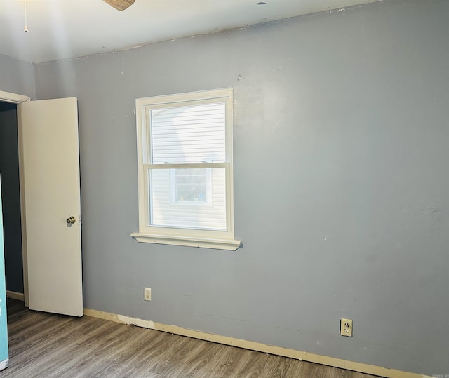 unfurnished room with baseboards and wood finished floors