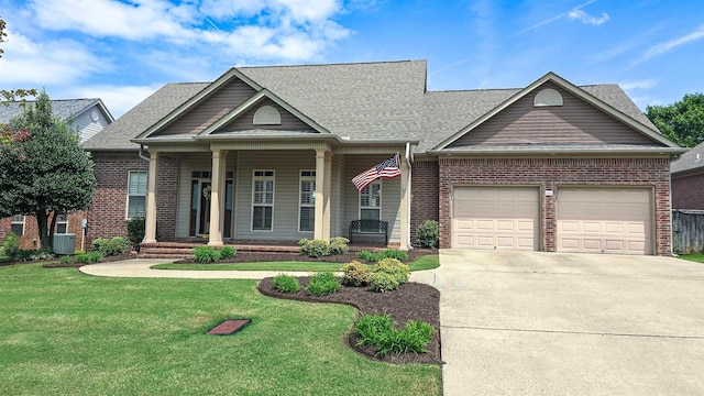 view of front of property with covered porch, a garage, brick siding, driveway, and a front yard