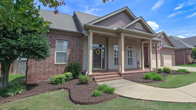 view of front of property featuring brick siding, a porch, an attached garage, fence, and driveway