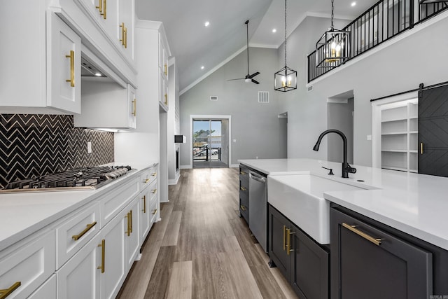 kitchen with stainless steel appliances, a barn door, a sink, and light countertops