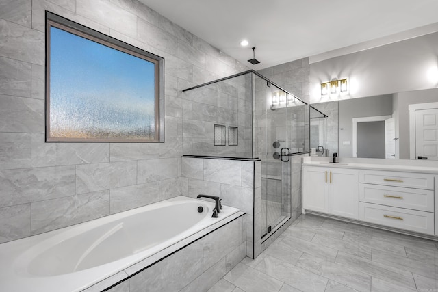 full bath featuring a stall shower, a garden tub, and vanity