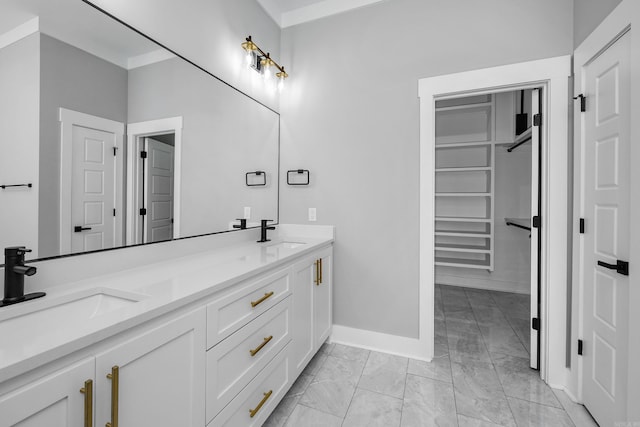 full bathroom with a walk in closet, marble finish floor, a sink, and double vanity