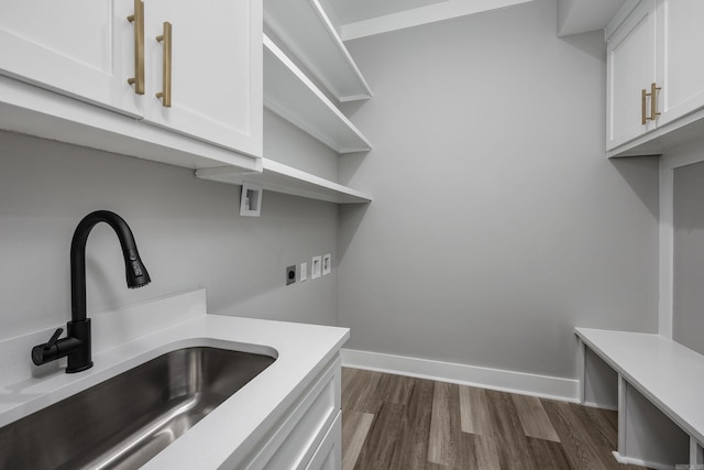 laundry room featuring hookup for a washing machine, cabinet space, a sink, electric dryer hookup, and baseboards