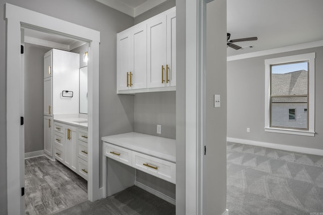 interior space with a ceiling fan, vanity, and baseboards