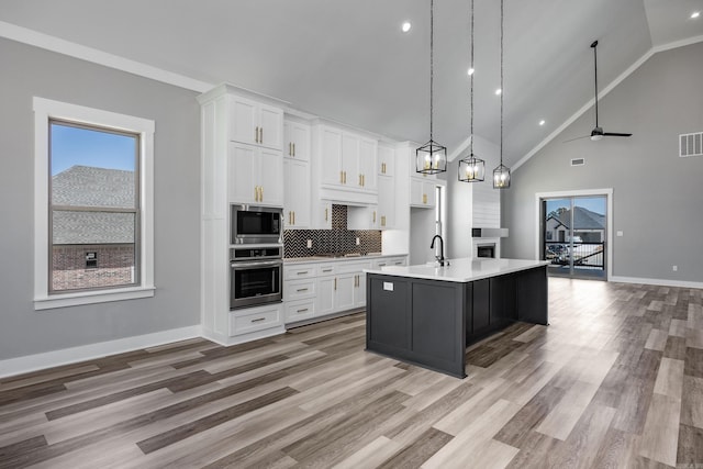 kitchen featuring visible vents, stainless steel appliances, light countertops, and white cabinetry