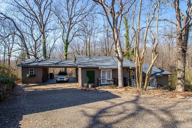 view of front of property with a carport, a porch, and gravel driveway