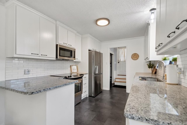 kitchen with tasteful backsplash, appliances with stainless steel finishes, white cabinets, a sink, and light stone countertops